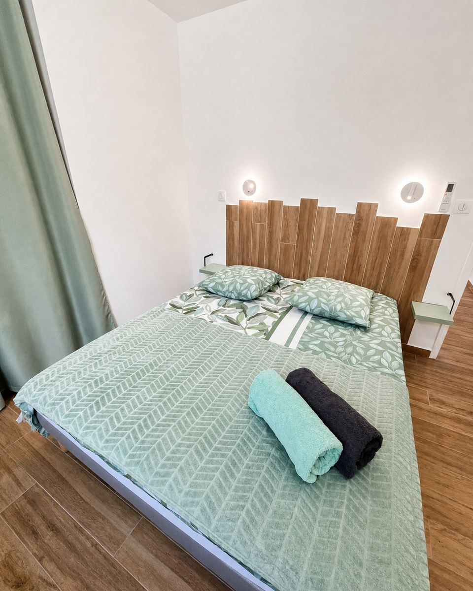 Chambre climatisée aux tons vert d eau avec liseuses individuelles